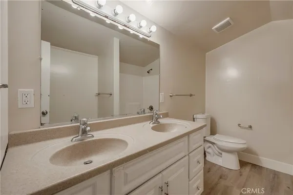 a bathroom with a sink double vanity and toilet