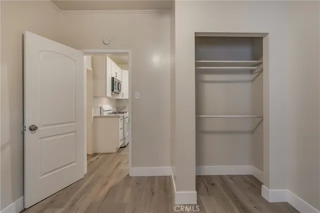 a view of walk in closet with wooden floor