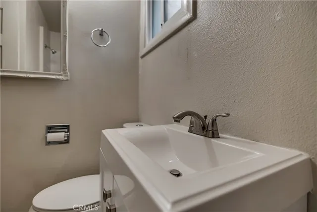 a view of an empty room with wooden floor and a ceiling fan