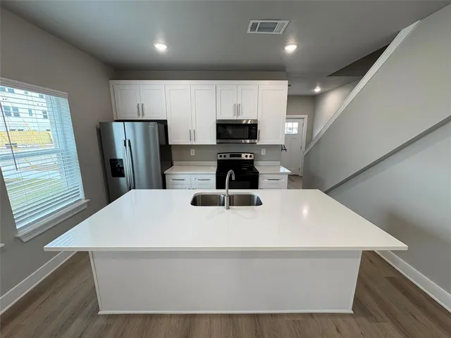 a kitchen with stainless steel appliances a refrigerator and a sink