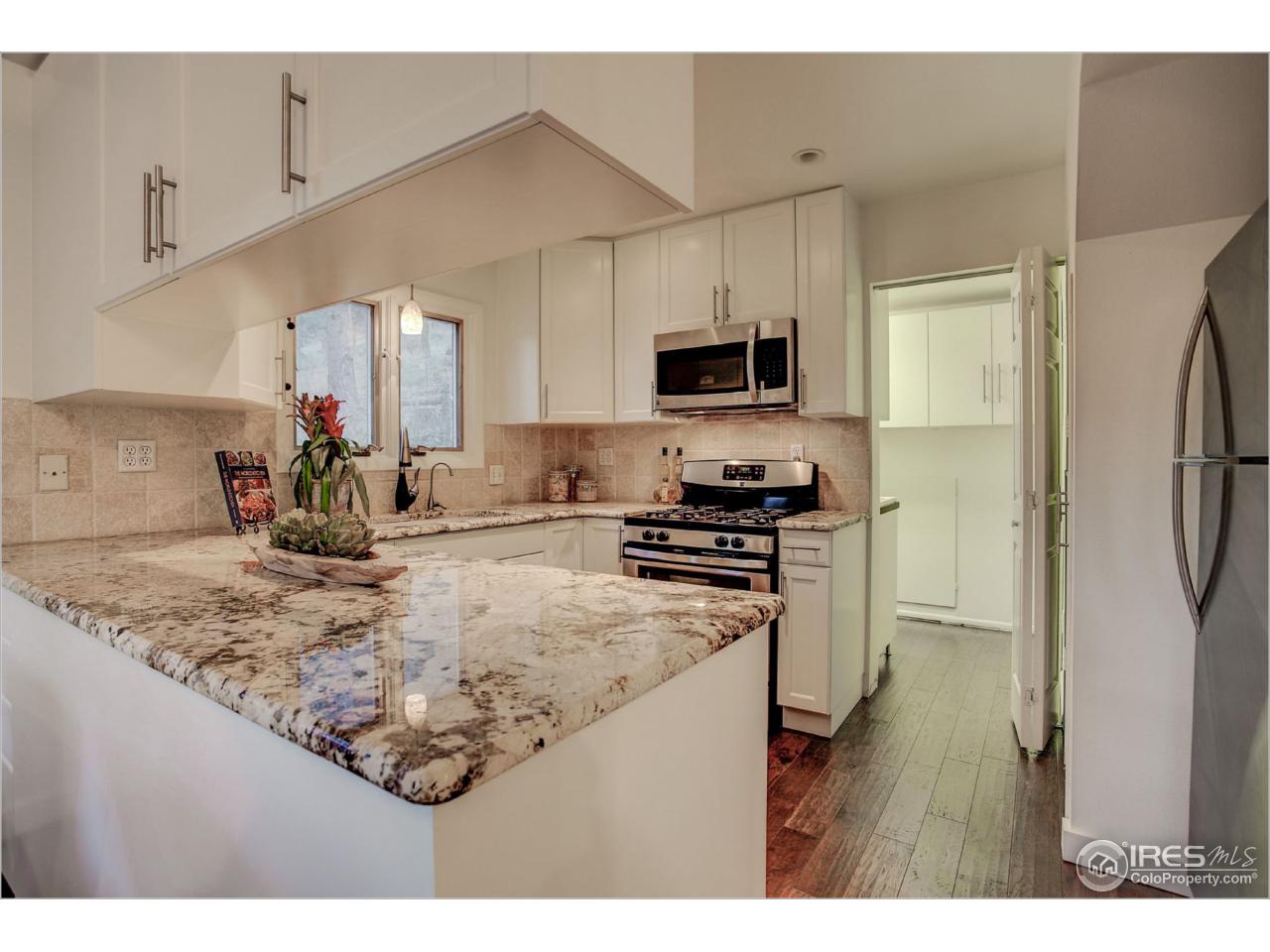 765 Pine Brook Road Boulder, CO 80304 - Photo 16 of 37 a kitchen with kitchen island a sink stainless steel appliances and cabinets