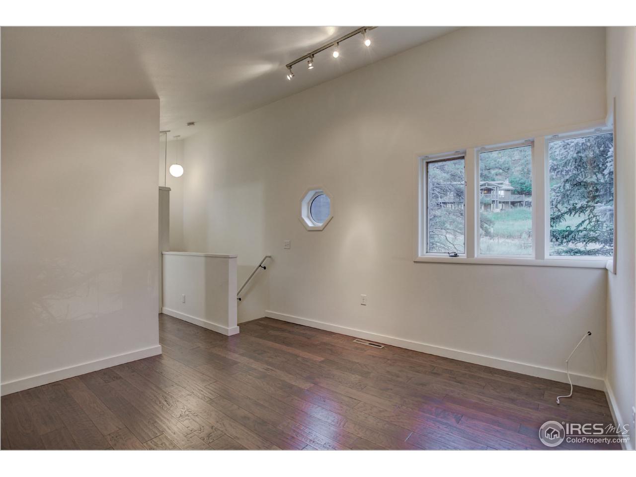 765 Pine Brook Road Boulder, CO 80304 - Photo 22 of 37 an empty room with wooden floor and windows