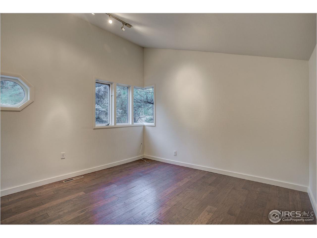 765 Pine Brook Road Boulder, CO 80304 - Photo 32 of 37 a view of an empty room with wooden floor and a window