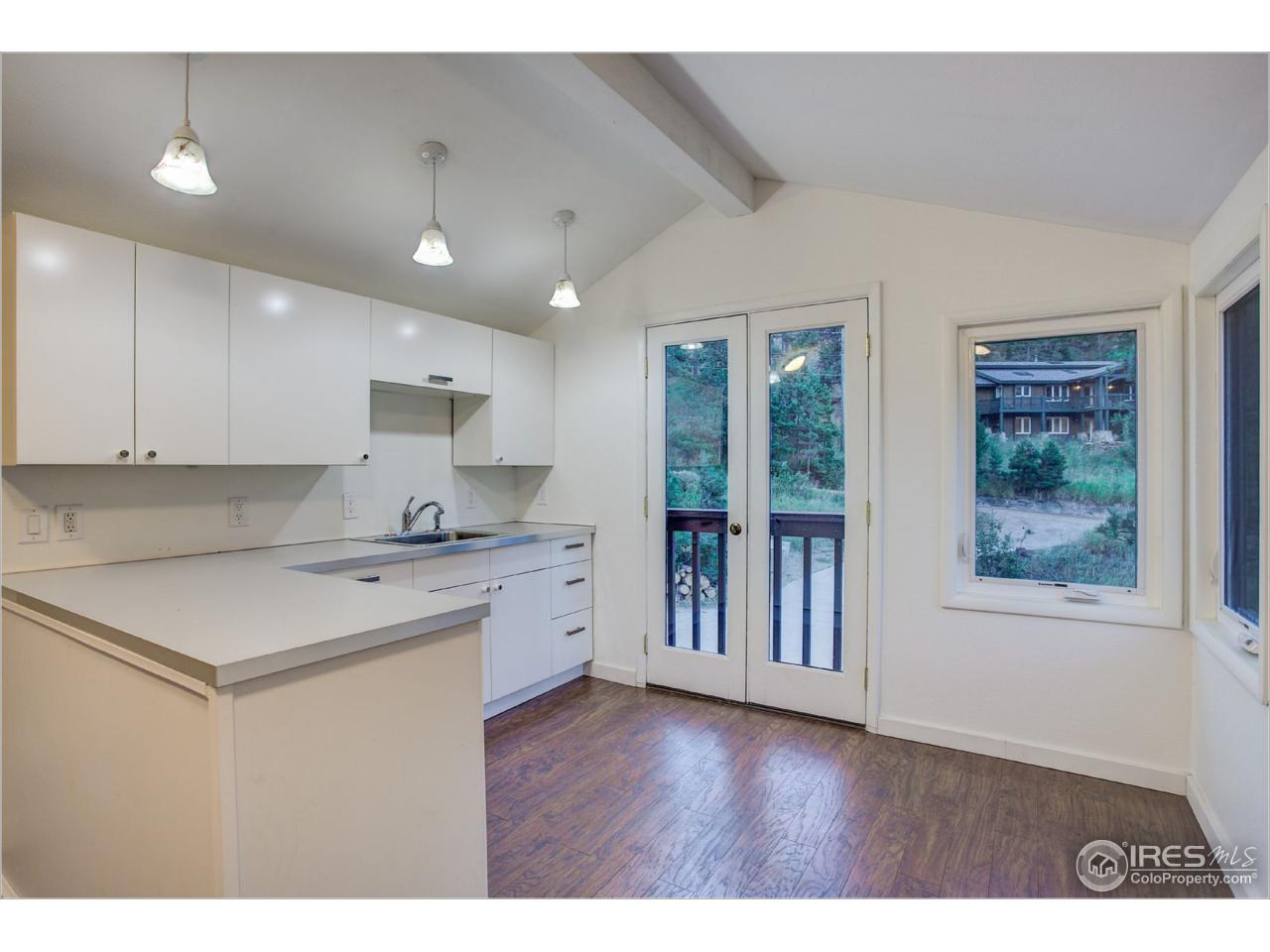 765 Pine Brook Road Boulder, CO 80304 - Photo 34 of 37 a kitchen with stainless steel appliances granite countertop a stove a sink and a refrigerator with wooden floor