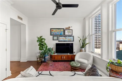 a living room with furniture a flat screen tv and a potted plant