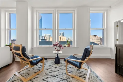 a living room with furniture a rug and a large window