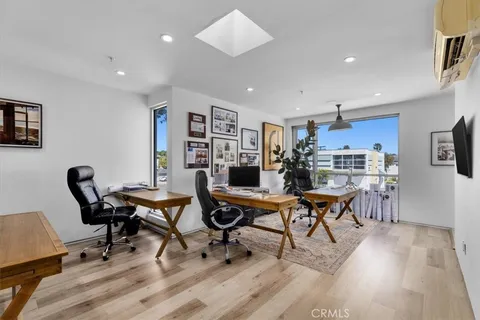 a workspace with a desk and chair with wooden floor