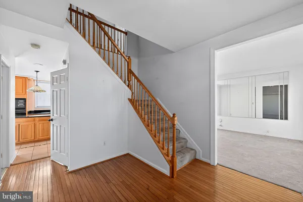 a view of a hallway with wooden floor and staircase