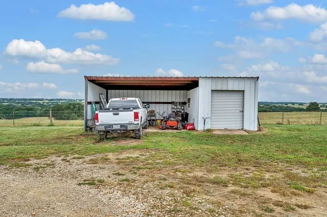 a car parked in the grass near a house