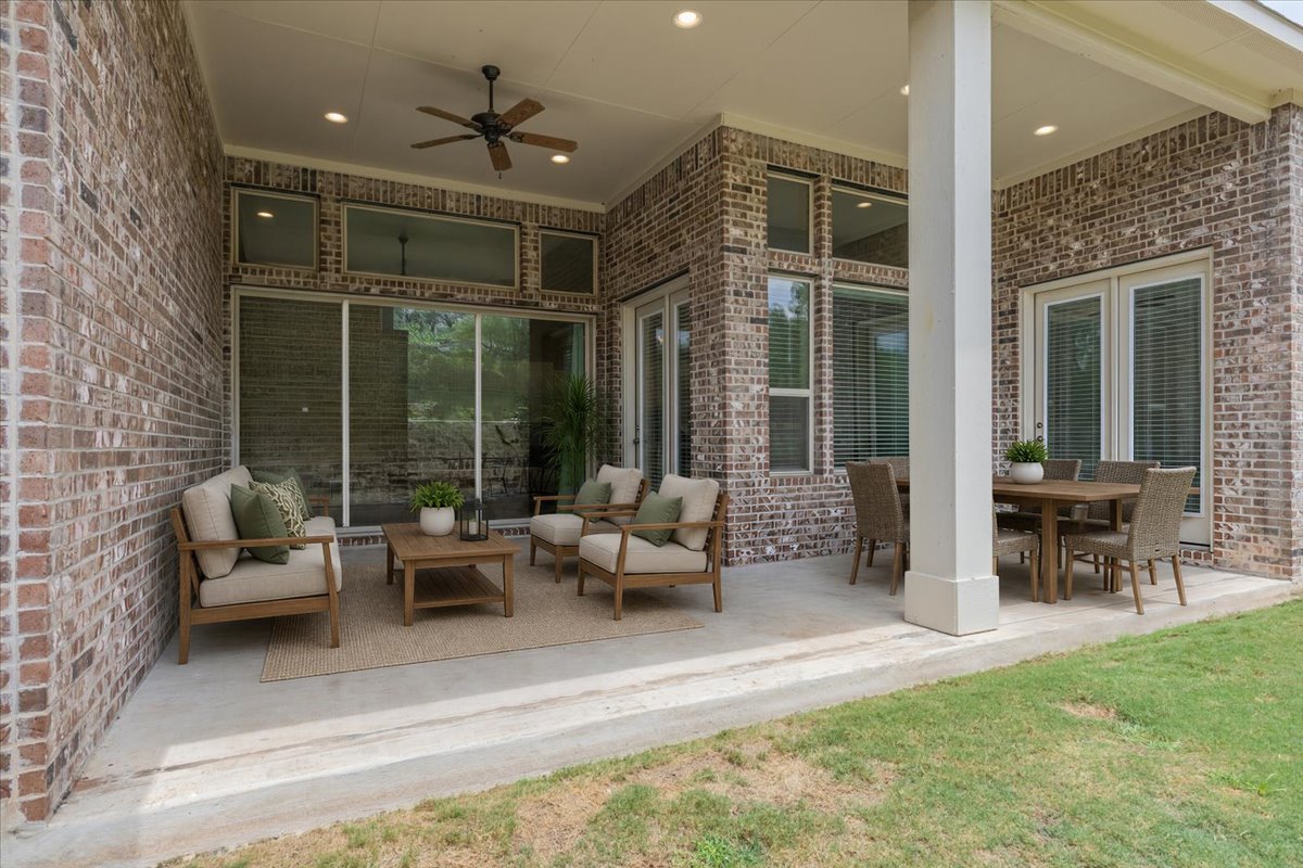 320 Raptor Beak Way Cedar Creek, TX 78612 - Photo 37 of 40 An inviting covered patio offers ample space for al fresco dining and relaxed seating, seamlessly blending indoor and outdoor living.