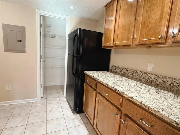 a kitchen with granite countertop a refrigerator and a sink