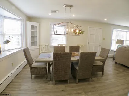 a dining room with furniture a chandelier and wooden floor