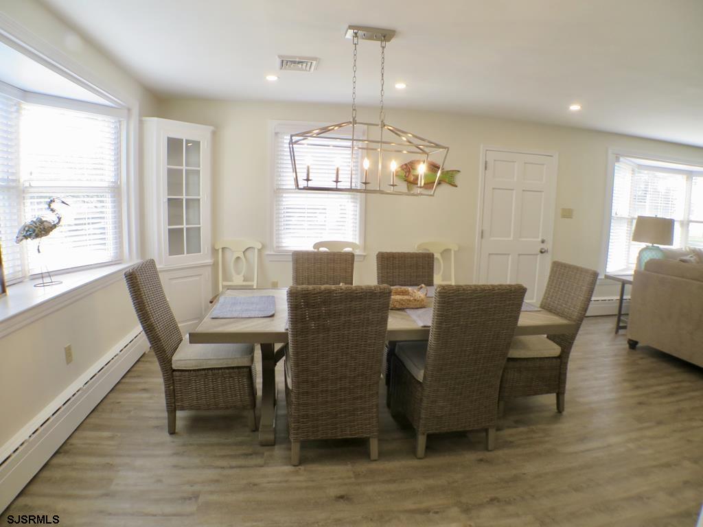 814 Wesley Road Ocean City, NJ 08226 - Photo 10 of 29 a dining room with furniture a chandelier and wooden floor