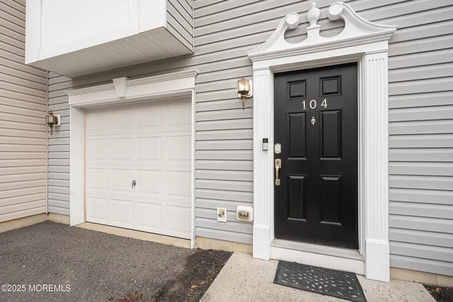 a living room with couches and a view of kitchen