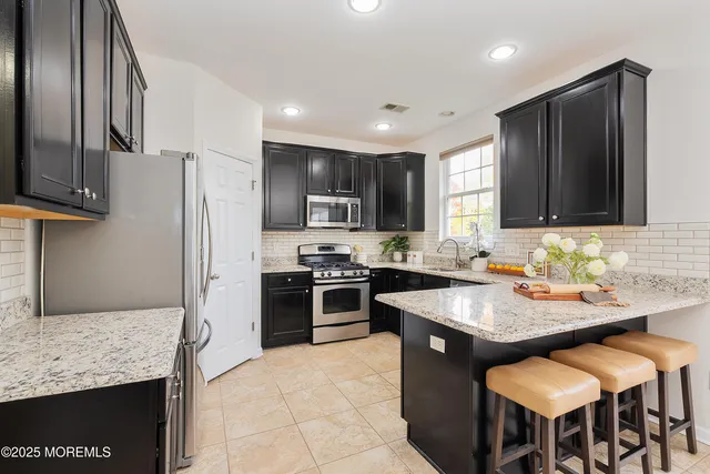 a kitchen with granite countertop stainless steel appliances cabinets a sink and a counter top space