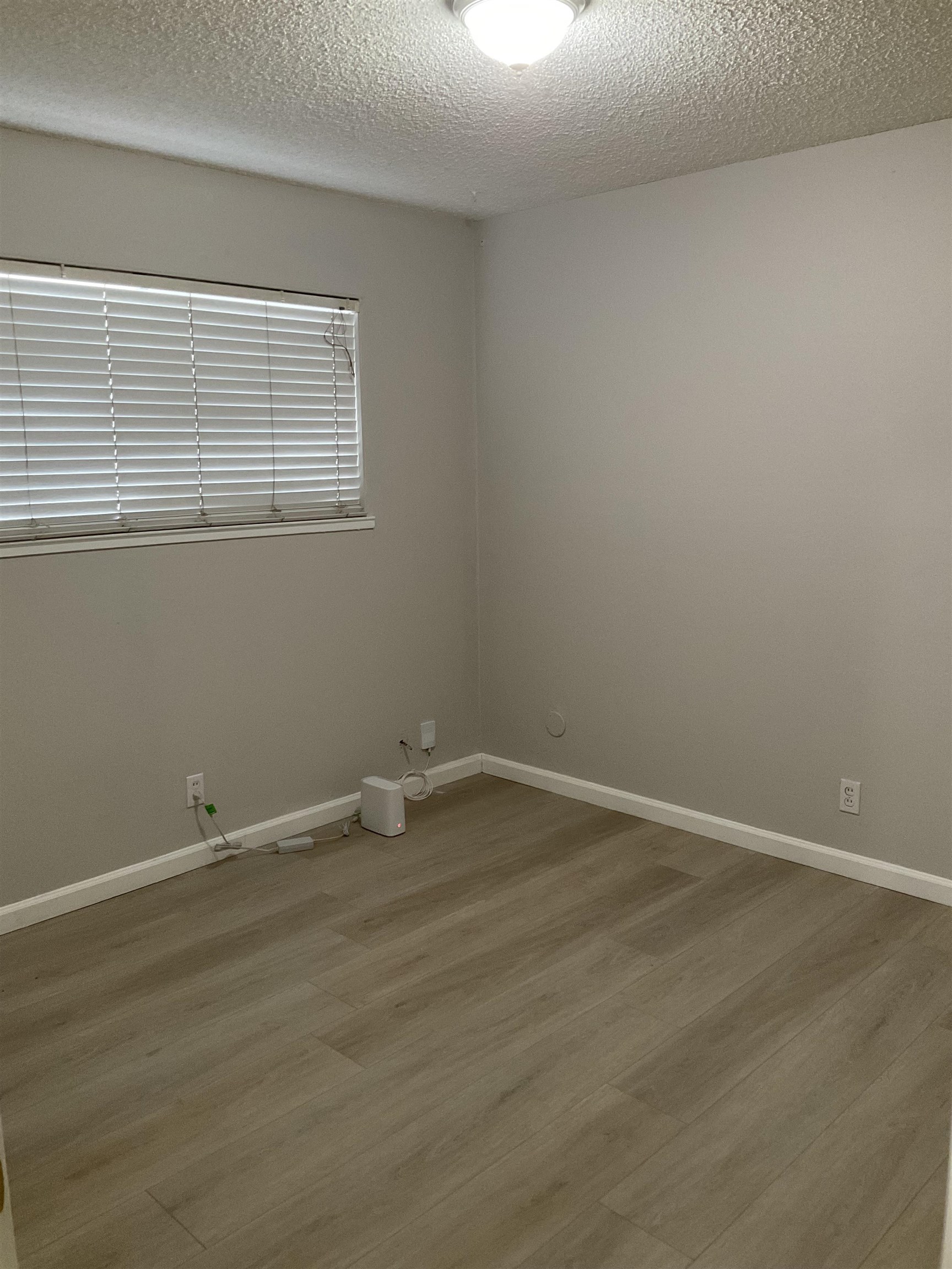 1108 West 5th Street, Unit 2 Antioch, CA 94509 - Photo 5 of 6 a view of an empty room with wooden floor and a window