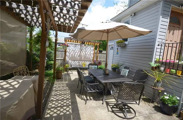 a view of a patio with table and chairs under an umbrella