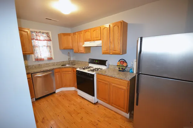 a kitchen with a sink a stove a refrigerator a center island and a window