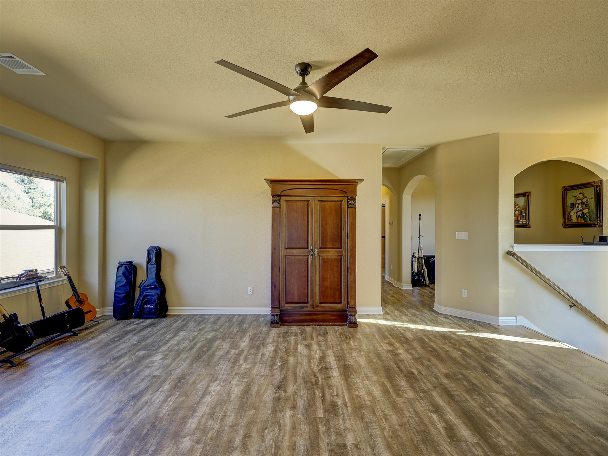 307 Duffy Lane Austin, TX 78738 - Photo 17 of 40 a view of a livingroom with wooden floor and a ceiling fan
