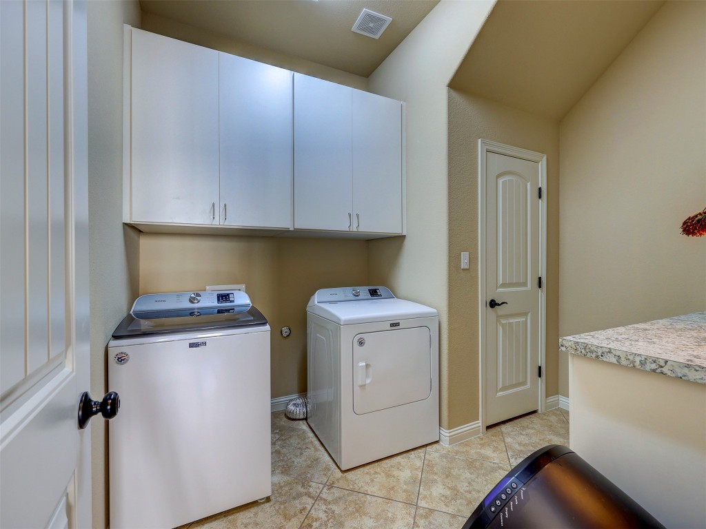307 Duffy Lane Austin, TX 78738 - Photo 28 of 40 Laundry room featuring cabinet space, washer and dryer, and light tile patterned floors