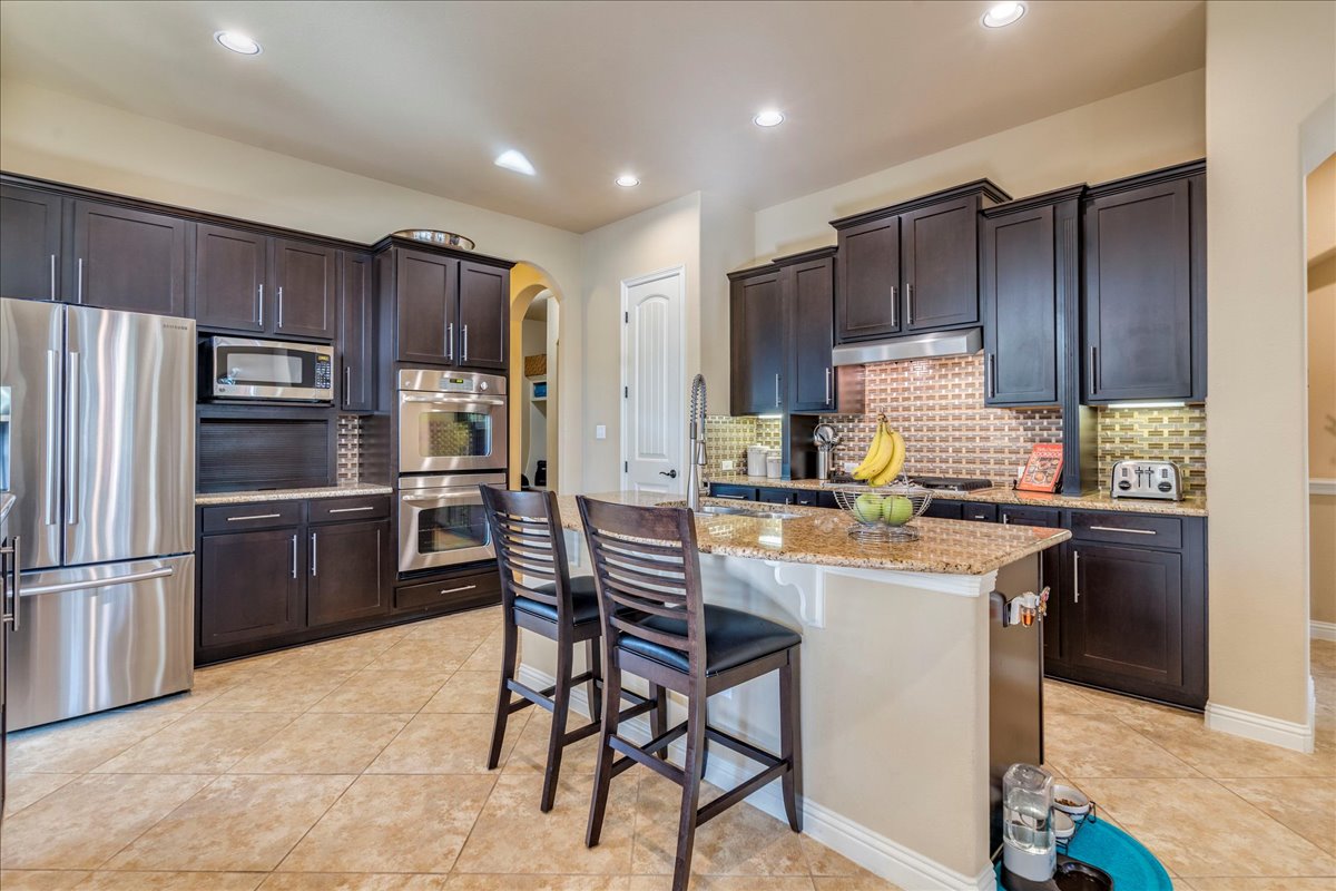 307 Duffy Lane Austin, TX 78738 - Photo 7 of 40 a kitchen with kitchen island a refrigerator stove microwave and cabinets