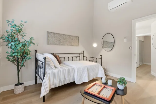 a bedroom with bed and a potted plant