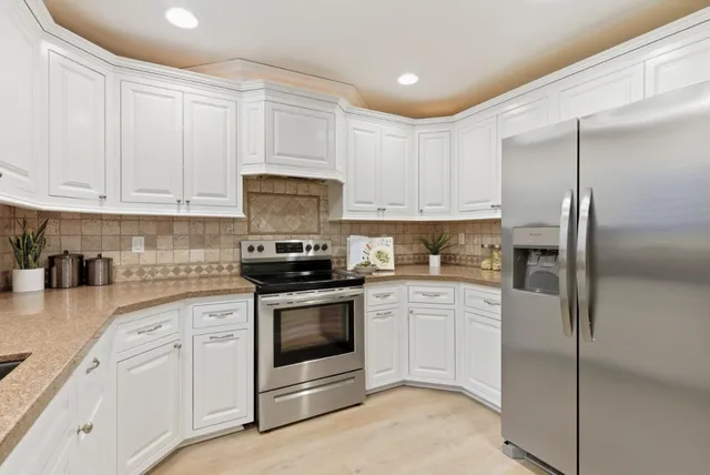 a kitchen with white cabinets and white appliances