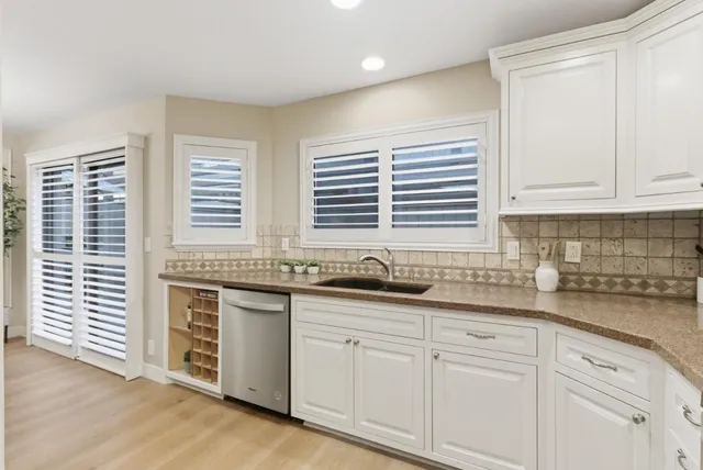 a kitchen with granite countertop white cabinets and white appliances
