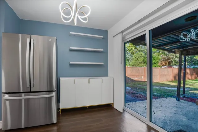 a view of a kitchen with a fridge and wooden floor