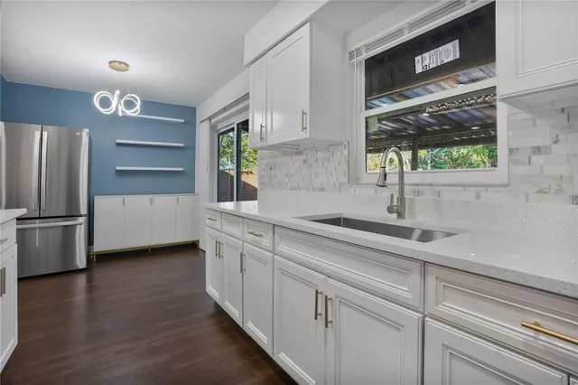 a kitchen with stainless steel appliances white cabinets and a window