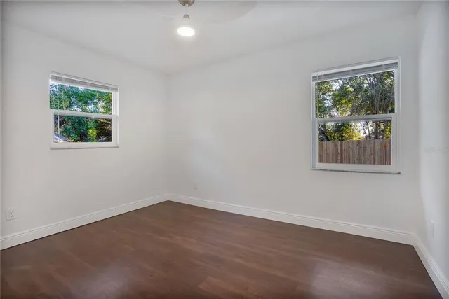 a view of a room that has wooden floor and window