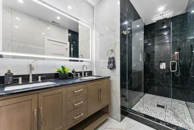a spacious bathroom with a tub a mirror and shower