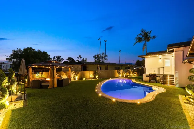 a front view of a house with swimming pool having outdoor seating
