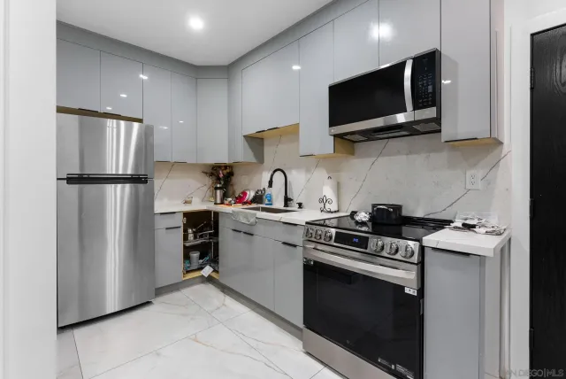 a kitchen with a dining table chairs and refrigerator
