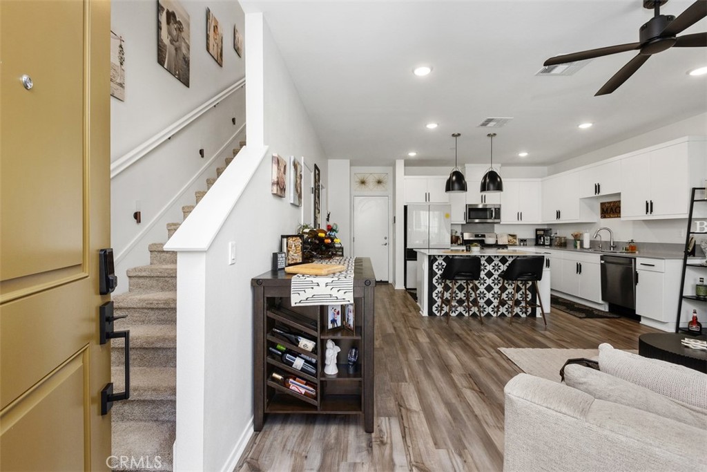 344 Zest Lane Fallbrook, CA 92028 - Photo 5 of 36 a kitchen with stainless steel appliances kitchen island granite countertop a refrigerator a sink a stove and white cabinets with wooden floor