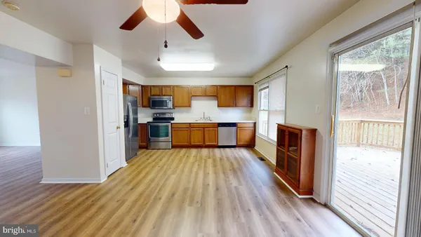 a large kitchen with wooden floor and stainless steel appliances