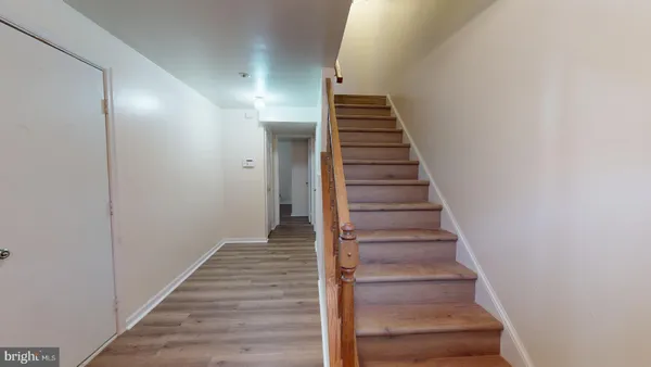 a view of a hallway with wooden floor and entryway