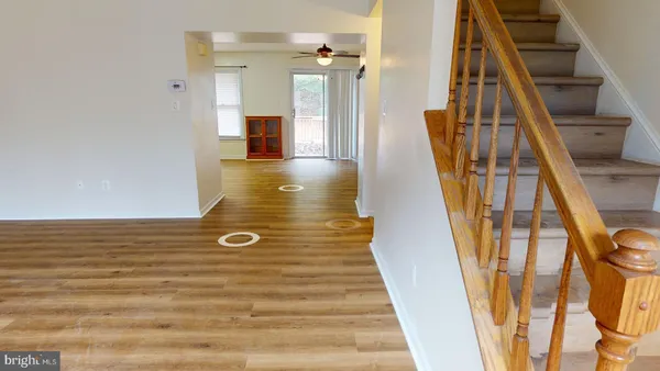 a view of a hallway with wooden floor and staircase