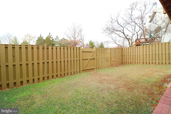 a view of backyard space with wooden fence