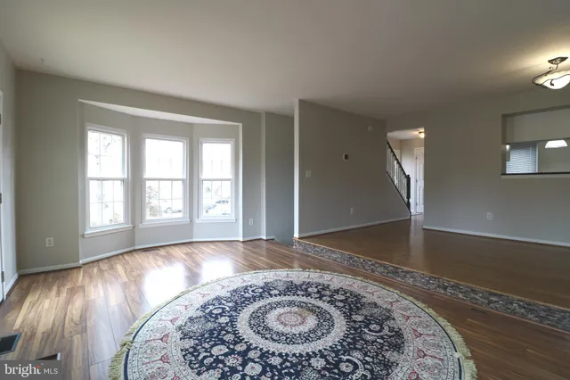 an empty room with a fireplace and wooden floor