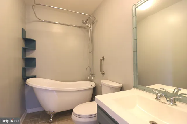 a white toilet sitting next to a bathroom sink and vanity