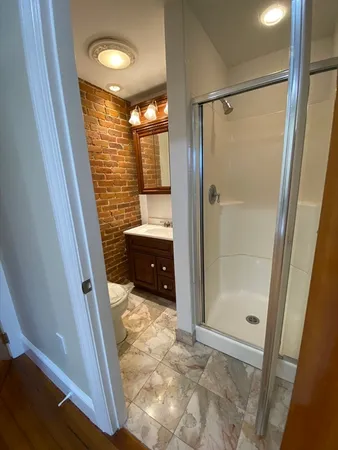 a view of walk in closet with glass door and shower