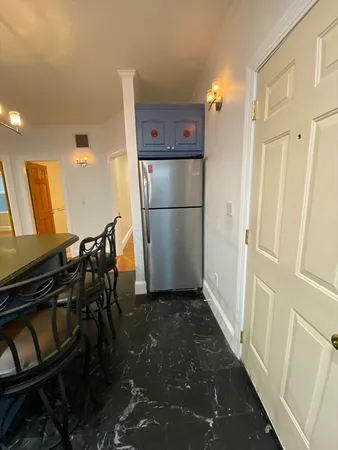 a view of a kitchen with refrigerator and wooden floor