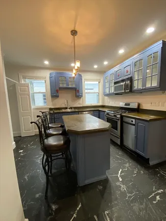 a kitchen with stainless steel appliances granite countertop a sink counter space and a stove top oven