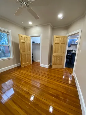 a view of empty room with wooden floor