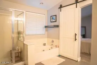 a view of a hallway with wooden floor and a bathroom