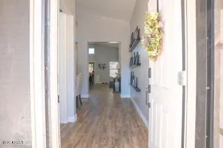 a view of a hallway with wooden floor and a bathroom