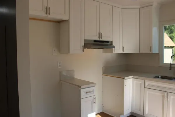 a kitchen with stainless steel appliances white cabinets and a sink