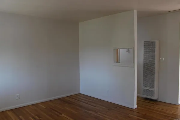 a view of an empty room with wooden floor