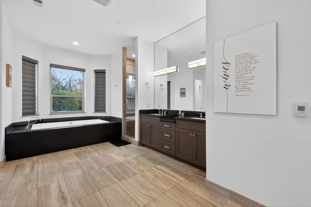 a view of a yard in front of a house with plants and large tree